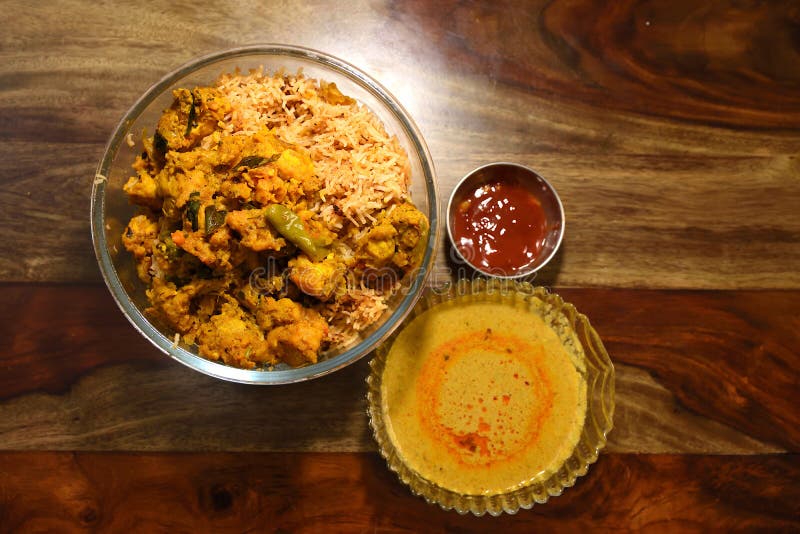 Indian Chicken Biryani served in a glass bowl with curry and sause over wooden background. Chicken dum biryani stock images, royalty-free photos and pictures