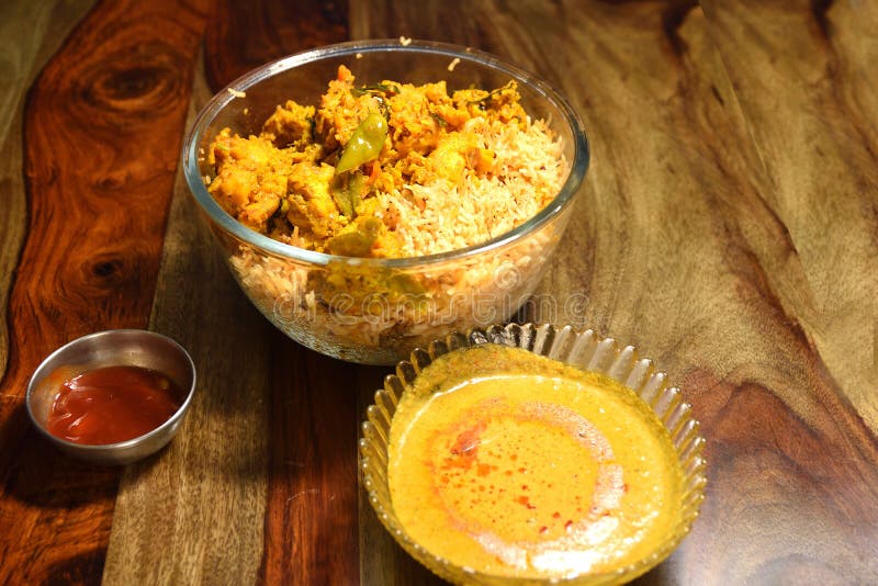 Indian Chicken Biryani served in a glass bowl with curry and sause over wooden background. Chicken dum biryani stock images, royalty-free photos and pictures