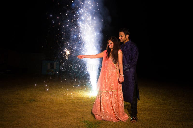 indian couple traditional wear celebrating diwali festival sparkler firecrackers outdoor park copy space to 198479544