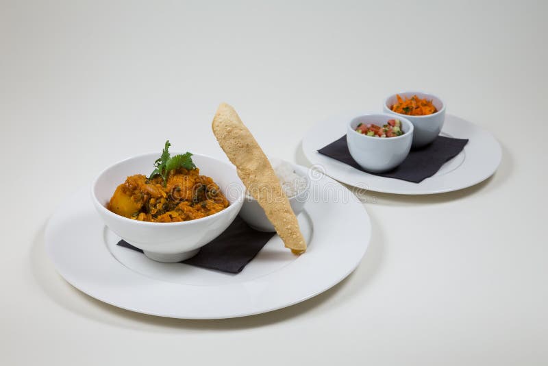 Indian Curry in a white bowl with rice on a white plate on a white background isolated stock photo Indian Curry in a white bowl with rice on a white plate on a white background isolated stock photo