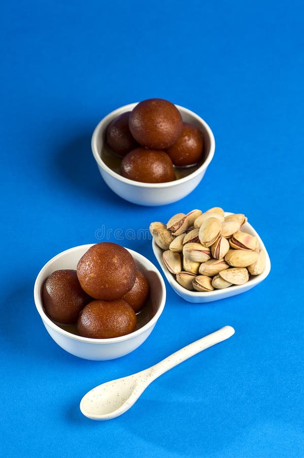 Indian Dessert Gulab Jamun In Bowl With Spoon On Blue Background