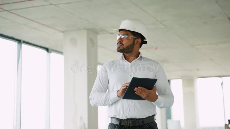 Indian engineer reviewing construction project data with tablet on-site stock video footage