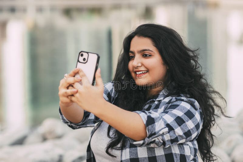 An Indian Girl Takes a Selfie on Her Phone while Sitting on the Embankment  while Walking in the City. Stock Photo - Image of nature, female: 254287956