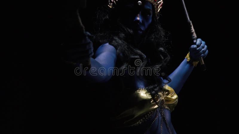 Kali with blue skin and golden clothes is dancing with the blades, close up