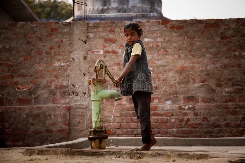 Indian little girl on hand-pump