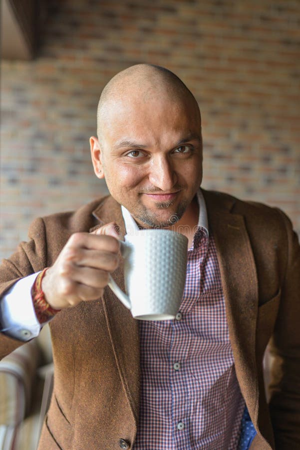 Indian Man Drinking Coffee and Looking at Camera Smiling Stock Photo