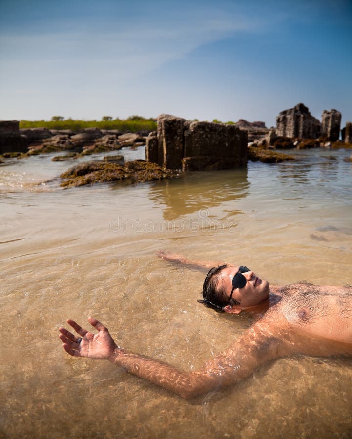 Indian man swimming at ocean beach