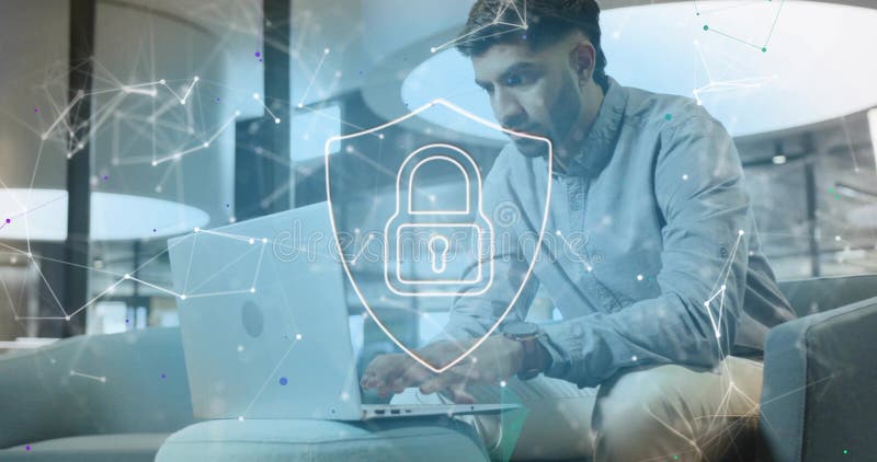 Indian man typing on laptop while sitting on sofa in office lounge, with network lock overlay royalty free stock images
