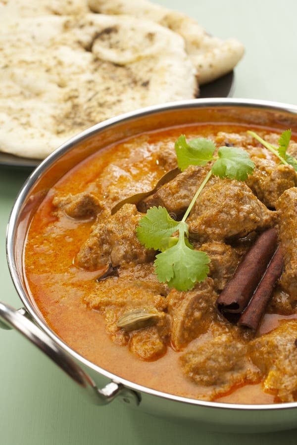 Indian curry lamb rogan josh in a steel karahi, with naan bread. Indian curry lamb rogan josh in a steel karahi, with naan bread.