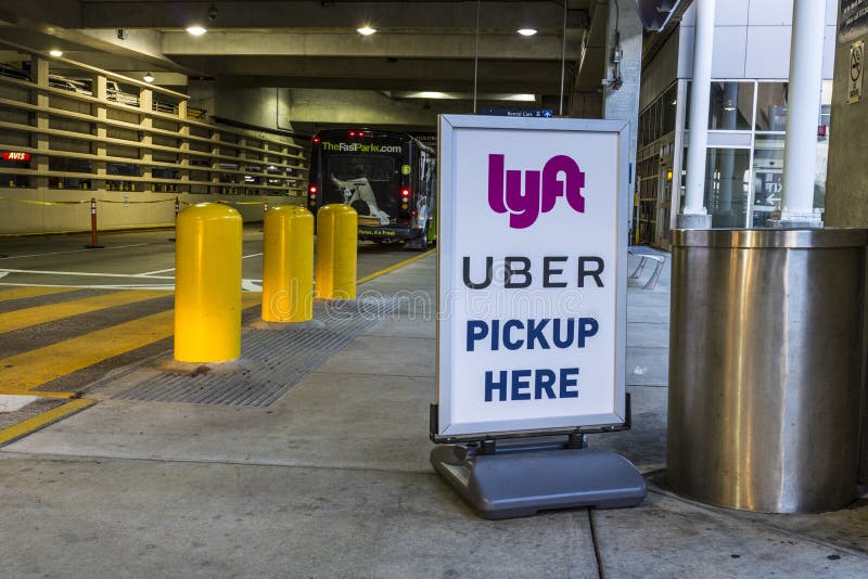 Indianapolis - Circa Juli 2017: Rit die bedrijven Lyft en Uber-bestelwagenvlek delen bij luchthaven I royalty-vrije stock foto's Indianapolis - Circa Juli 2017: Rit die bedrijven Lyft en Uber-bestelwagenvlek delen bij luchthaven I royalty-vrije stock foto's