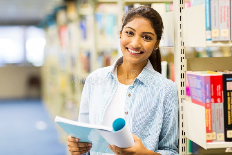 Indiańska szkoły wyższa dziewczyna czyta książkę w bibliotece