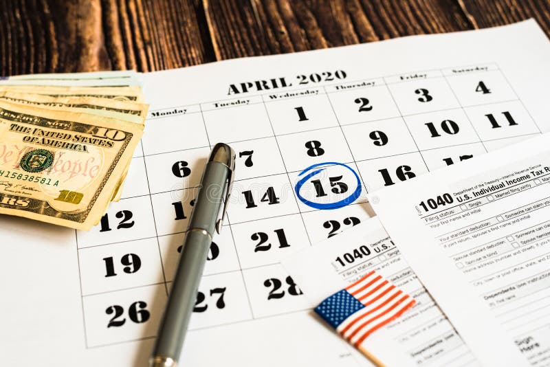 Indicado en un calendario el día de pago del impuesto con el formulario 1040 foto de archivo Indicado en un calendario el día de pago del impuesto con el formulario 1040 foto de archivo