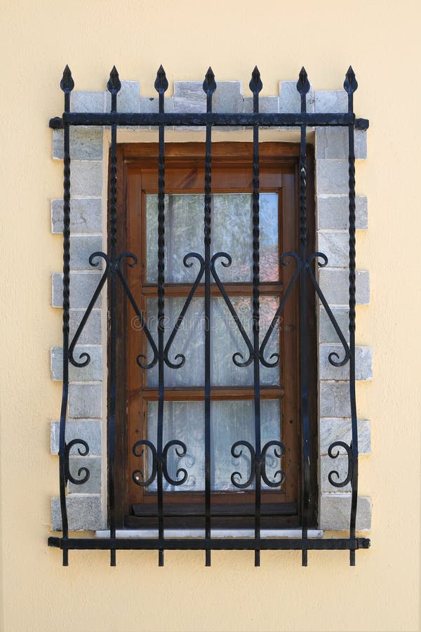Details of a window with decorative, wrought iron, security bars. Details of a window with decorative, wrought iron, security bars.