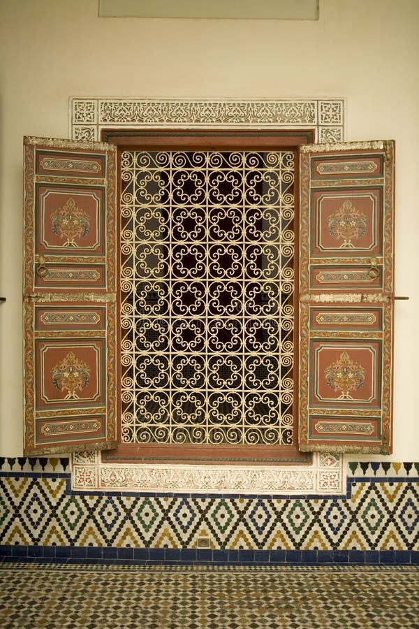 Details of an ornate window and shutters with a traditional Moroccan mosaic design and a iron security grill. Details of an ornate window and shutters with a traditional Moroccan mosaic design and a iron security grill.