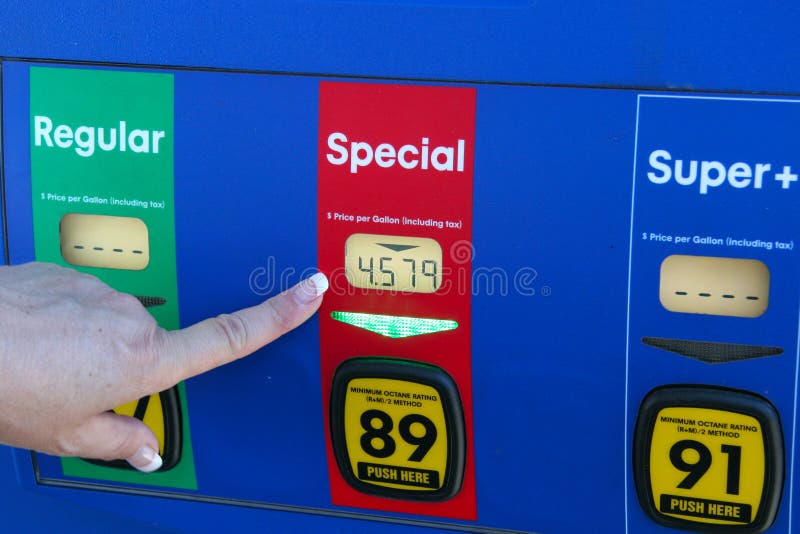 A woman's hand pointing to high gas price at the pump. A woman's hand pointing to high gas price at the pump.