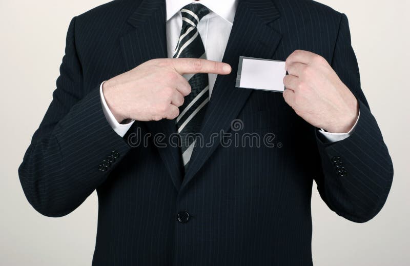 Business man wearing a suit pointing to a blank name badge - insert your own brand and information. Business man wearing a suit pointing to a blank name badge - insert your own brand and information