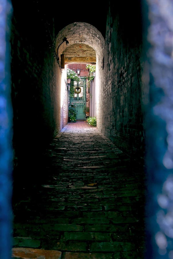 Colorful doorway at the end of a spooky looking alley the light at the end of the tunnel lots of copy space on bottom. Colorful doorway at the end of a spooky looking alley the light at the end of the tunnel lots of copy space on bottom