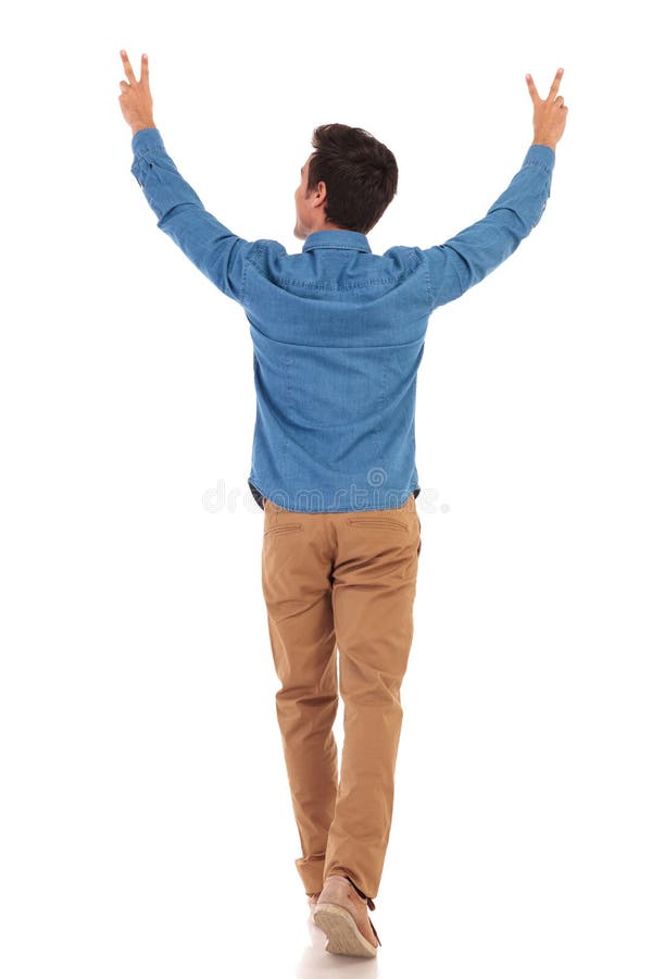 Back view of a casual man walking with hands in the air making the victory sign on white background. Back view of a casual man walking with hands in the air making the victory sign on white background