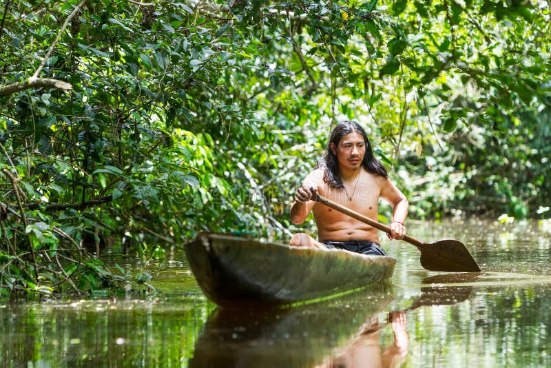 Indigenous Adult Man In Wooden Canoe