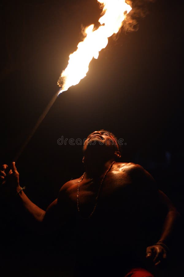Indigenous Fijian man holds a torch during a fire dance
