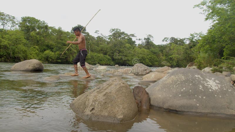 Indigenous Hunter Trying To Fish With A Spear In The Amazon Rainforest