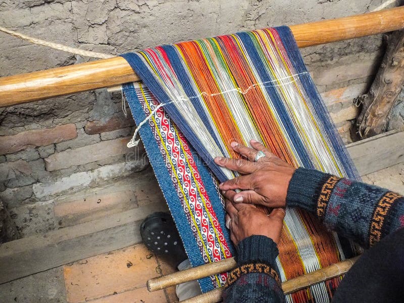 Indigenous Quechua man in the studio weaving wool on a traditional backstrap loom. This fabric is double woven. It has right side pattern on both sides Wool is from organically raised sheep in the Andes Mountains of Ecuador. Spinning and weaving are traditional crafts in village life. Indigenous Quechua man in the studio weaving wool on a traditional backstrap loom. This fabric is double woven. It has right side pattern on both sides Wool is from organically raised sheep in the Andes Mountains of Ecuador. Spinning and weaving are traditional crafts in village life.