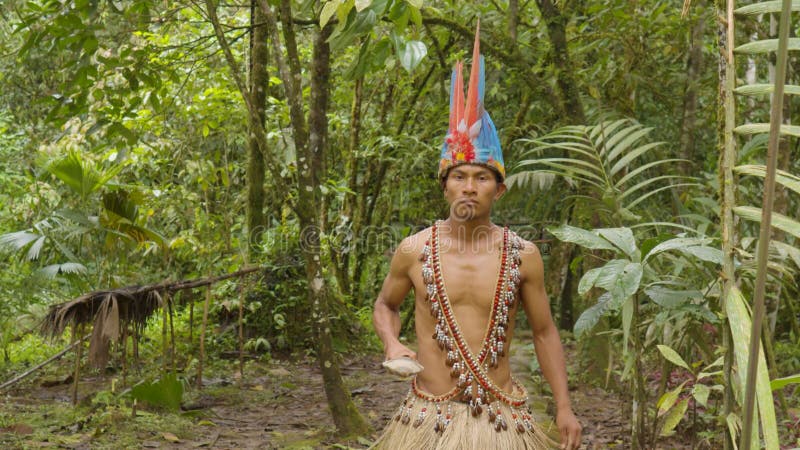 Indigenous Warrior Following The Viewer In The Amazon Jungle