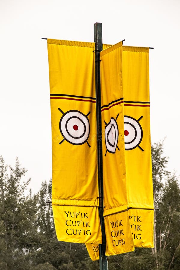 Indiginous- First Peoples Flag banner on post with traiditonal symbol on top and native word for stock photography