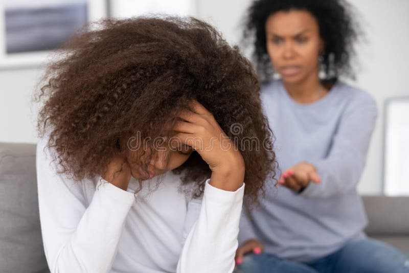 Indignada adolescente africana se retracta de la regañadura furiosa de su madre imagenes de archivo