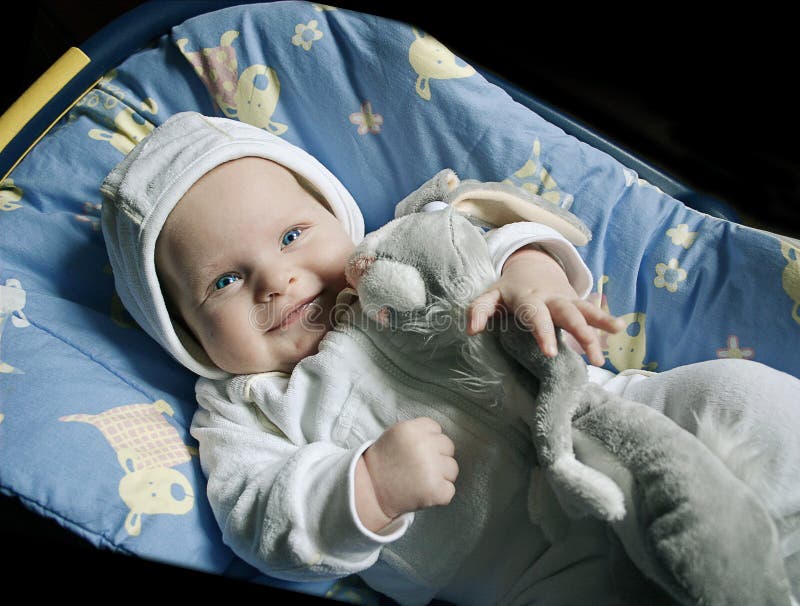 Indigo baby with a toy rabbit