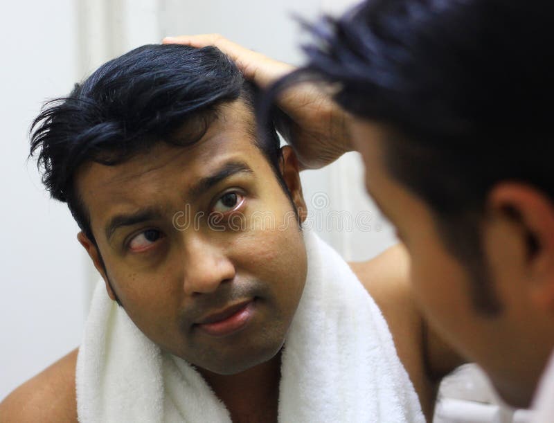 Indische Aziatische mens die voor zijn verschijning voor een spiegelschoonheid het stileren levensstijl zorgen Stilerend Haar stock afbeelding Indische Aziatische mens die voor zijn verschijning voor een spiegelschoonheid het stileren levensstijl zorgen Stilerend Haar stock afbeelding