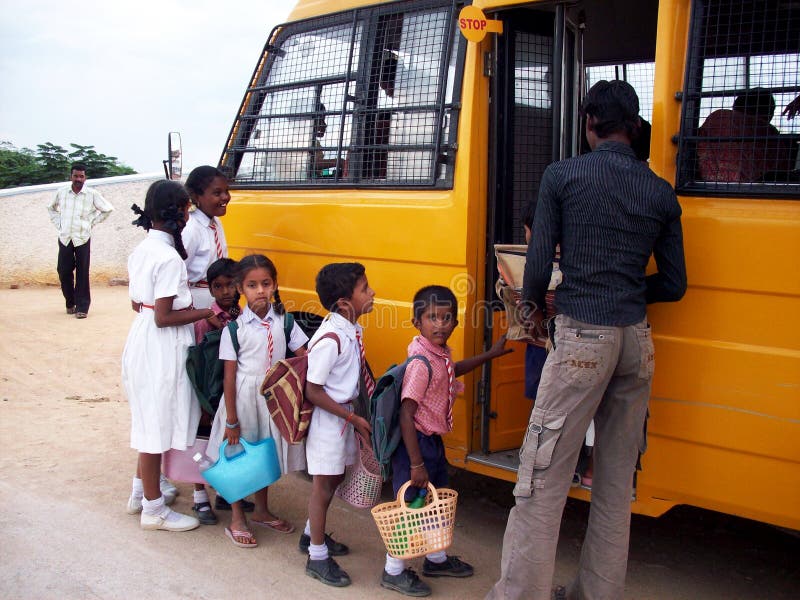 Indische Kinder, die in Schulbus einsteigen lizenzfreie stockfotos Indische Kinder, die in Schulbus einsteigen lizenzfreie stockfotos