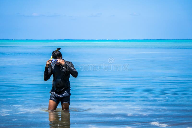 Indische man met snorkeluitrusting die uit het water komt stock fotografie Indische man met snorkeluitrusting die uit het water komt stock fotografie