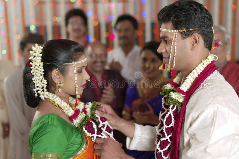 Indischer hindischer Bräutigam, der Braut betrachtet und Girlande in der Maharashtrahochzeit austauscht stockbilder Indischer hindischer Bräutigam, der Braut betrachtet und Girlande in der Maharashtrahochzeit austauscht stockbilder