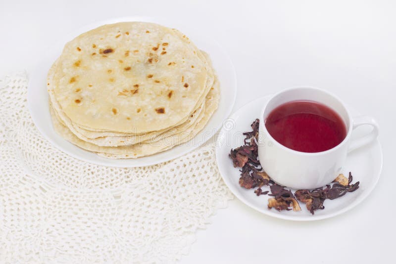 Indiskt chapati-bröd chapati på en vit platta med en mug rött te från granatäpplen på vit bakgrund matlagning royaltyfri bild