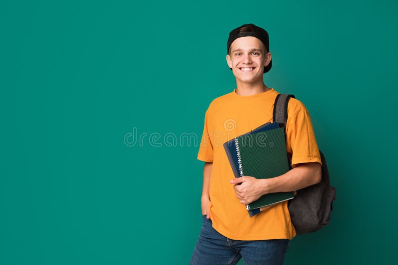 Individuo adolescente con los libros y la mochila sobre fondo imagen de archivo Individuo adolescente con los libros y la mochila sobre fondo imagen de archivo