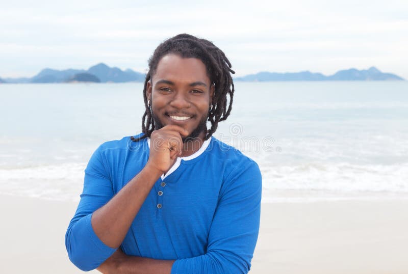 Individuo afroamericano atractivo con los dreadlocks en la playa foto de archivo Individuo afroamericano atractivo con los dreadlocks en la playa foto de archivo