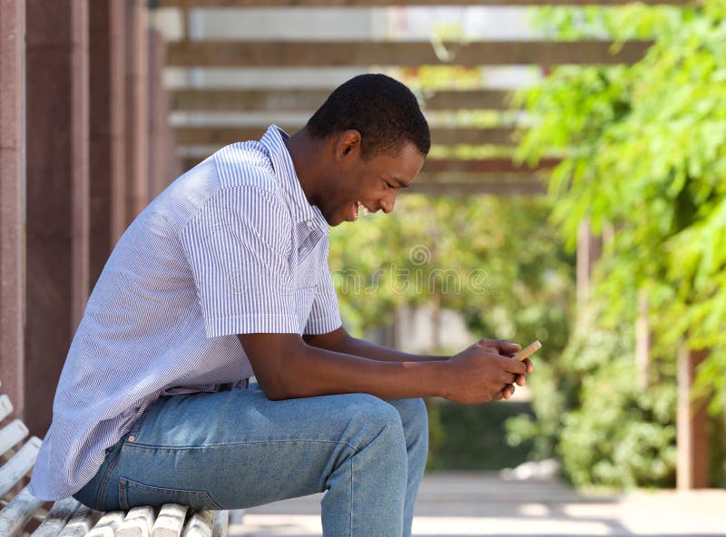 Individuo afroamericano fresco que mira el teléfono celular