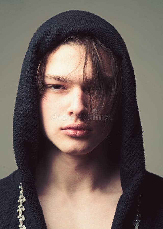 Individuo en cara confiada en la capilla negra, fondo gris Machista en albornoz negra con la capilla, cierre para arriba Concepto imagen de archivo Individuo en cara confiada en la capilla negra, fondo gris Machista en albornoz negra con la capilla, cierre para arriba Concepto imagen de archivo