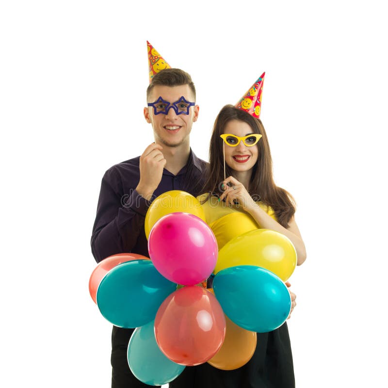 Individuo joven gay con una muchacha, sosteniéndose cerca de los vidrios del papel del ojo y de las porciones de globo coloreado foto de archivo libre de regalías Individuo joven gay con una muchacha, sosteniéndose cerca de los vidrios del papel del ojo y de las porciones de globo coloreado foto de archivo libre de regalías