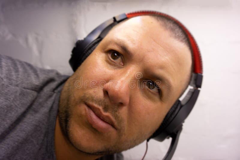 Individuo que hace una mueca de dolor con la cabeza joven del retrato de los auriculares stock de ilustración Individuo que hace una mueca de dolor con la cabeza joven del retrato de los auriculares stock de ilustración