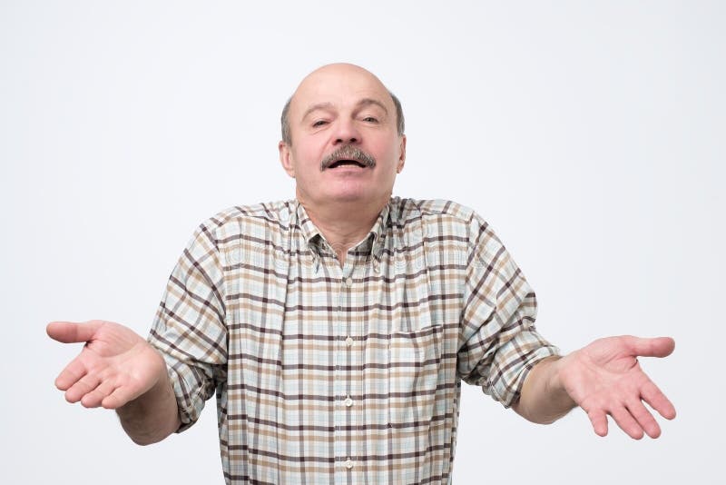 Indivíduo considerável confundido que mostra eu não tenho nenhum gesto da ideia, shrugging ombros e levantando a mão fotografia de stock Indivíduo considerável confundido que mostra eu não tenho nenhum gesto da ideia, shrugging ombros e levantando a mão fotografia de stock