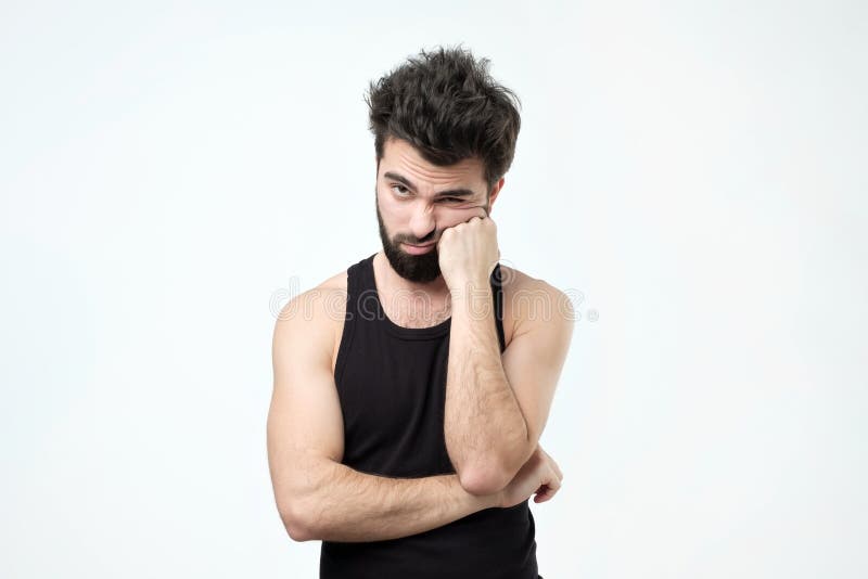 Indivíduo latino-americano cansado com barba, sendo esgotado e querendo obter o resto contra o fundo cinzento fotografia de stock Indivíduo latino-americano cansado com barba, sendo esgotado e querendo obter o resto contra o fundo cinzento fotografia de stock