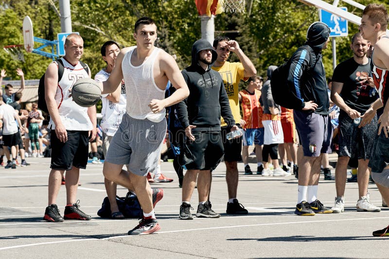 Indivíduos novos que jogam o basquetebol na rua na cidade fotografia de stock Indivíduos novos que jogam o basquetebol na rua na cidade fotografia de stock