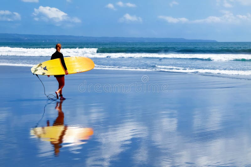 Indonesia, Bali Island, Kuta - October 10, 2017: Girl surfer with a surfboard walking along the beach. School of surfing in Bali. royalty free stock photo Indonesia, Bali Island, Kuta - October 10, 2017: Girl surfer with a surfboard walking along the beach. School of surfing in Bali. royalty free stock photo