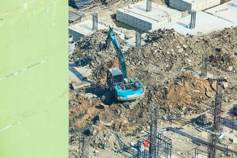 Industria dell'edilizia, sito concreto della costruzione di edifici Pali concreti conficcati in terra dall'escavatore al pozzo de immagine stock Industria dell'edilizia, sito concreto della costruzione di edifici Pali concreti conficcati in terra dall'escavatore al pozzo de immagine stock