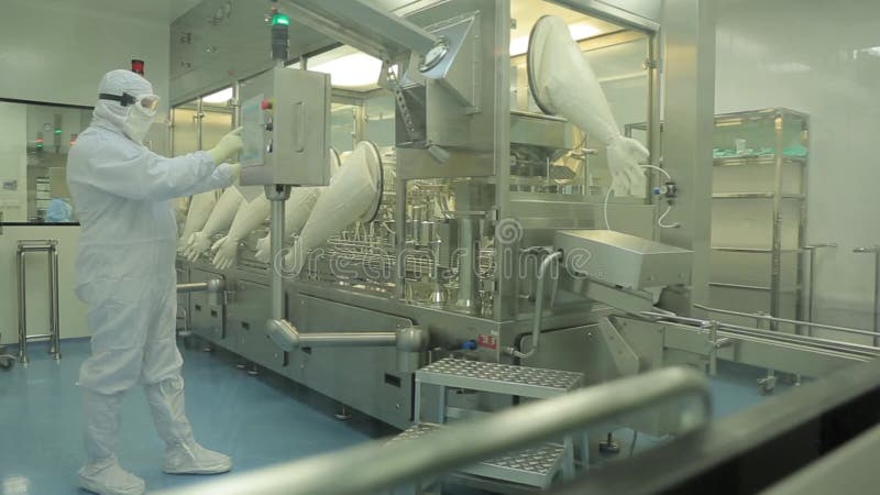 Industria farmaceutica Operaio maschio che ispeziona qualità delle pillole che imballano nella fabbrica farmaceutica automatico