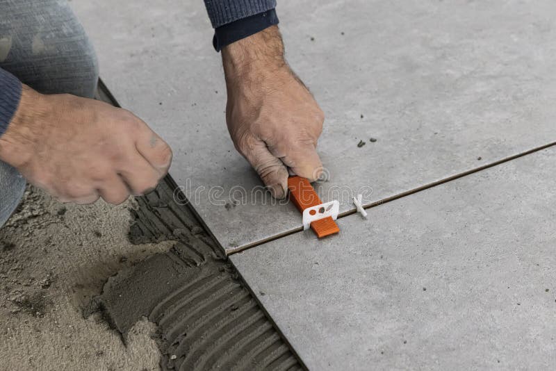 Industrial Ceramic Builder Worker Installing Floor Tile at Repair