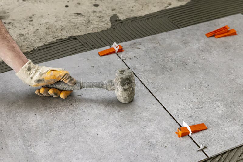 Industrial Ceramic Builder Worker Installing Floor Tile at Repair