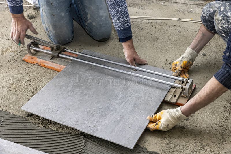 Industrial Ceramic Builder Worker Installing Floor Tile at Repair